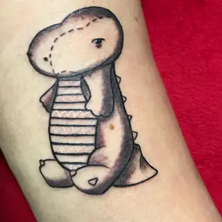 Tattoo von Tschiggy mit einem Dinosaurier im Bubblegum-Art-Stil