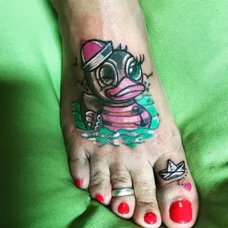 Tattoo von Tschiggy mit einer Ente und einem Papierboot im Bubblegum-Art-Stil