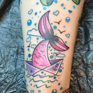 Tattoo von Tschiggy mit einem Papierboot im Bubblegum-Art-Stil